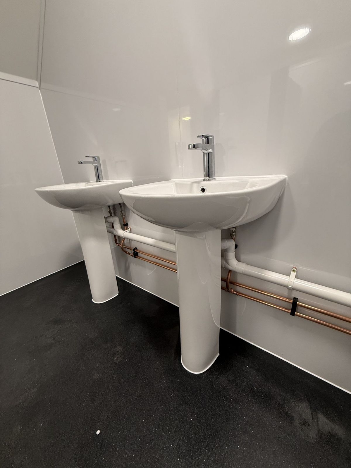 Commercial washroom fit-out with wall cladding and basins